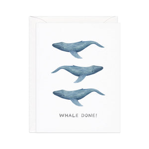 Greeting card with white background with images of three grey whales and gray text says, "Whale Done!". White envelope included. 
