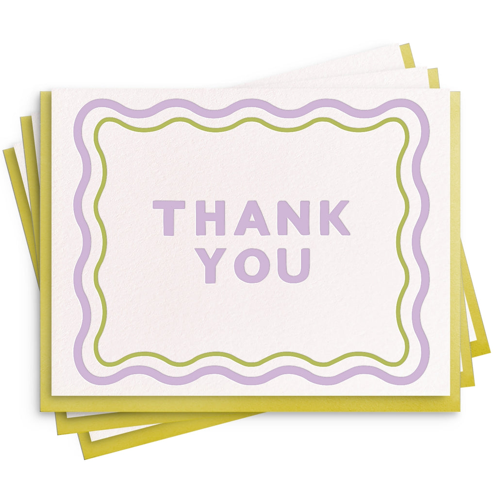 Note card with white background with lilac and green wavy border and lilac text says "Thank you". Olive envelope included. 