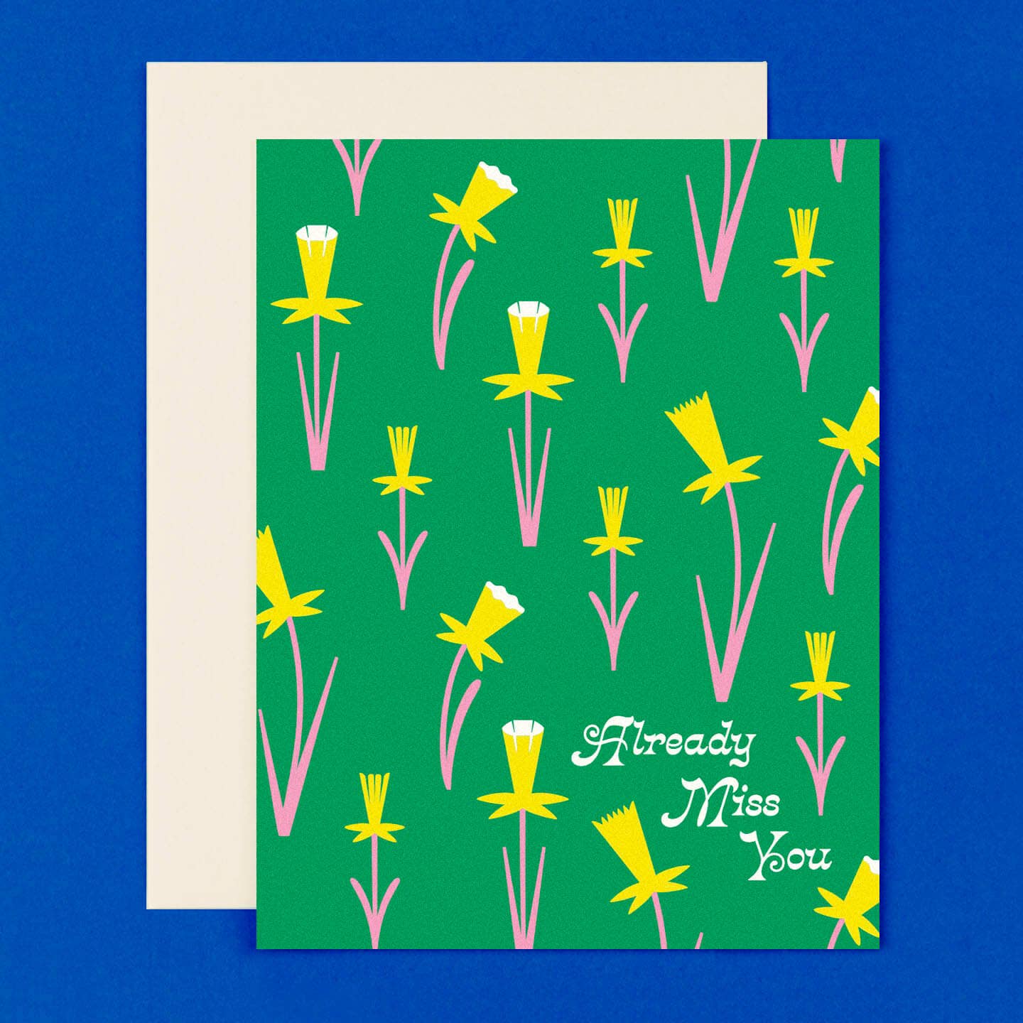 Greeting card with green background and images of yellow daffodils with pink stems and leaves and white text says, "Already miss you". White envelope included. 