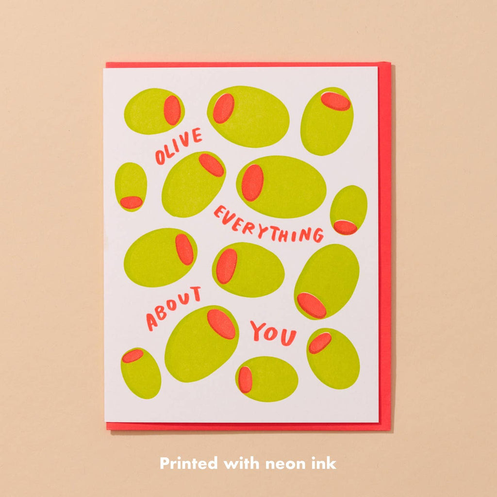 Greeting card with white background and images of green and red olives with red text says, "Olive everything about you". Red envelope included, 