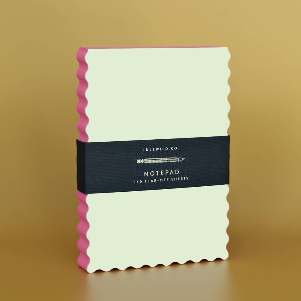 Notepad with cream paper and wavy edge with coral color.