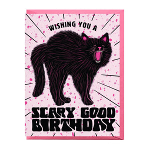 Greeting card with pink speckled background and image of a scary black cat and black text says, "Wishing you a scary good birthday". Pink envelope included.