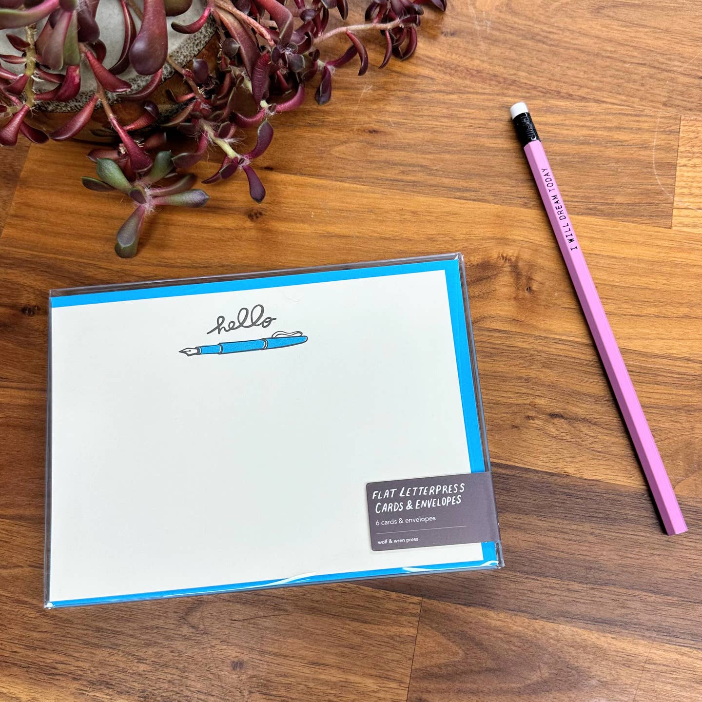 Image of note card set with white background and image of a bright blue fountain pen at top of card with black text says, "hello". Bright blue envelopes included.