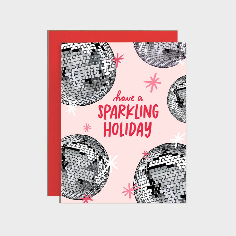 Greeting card with pink background and images of silver disco balls with red text says, "Have a sparkling holiday". Red envelope included. 