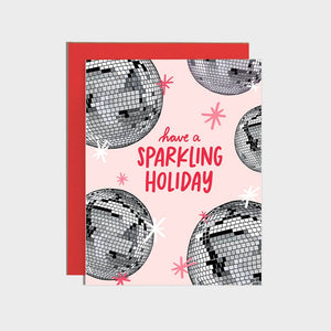 Greeting card with pink background and images of silver disco balls with red text says, "Have a sparkling holiday". Red envelope included. 