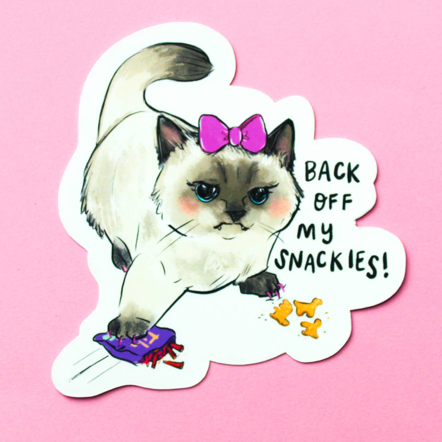 Decorative sticker with white background and image of a white kitty wearing a pink bow on it's head with a paw on a bag of snacks. Black text says, "Back off my snackies!".