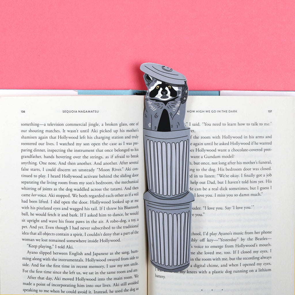 Image of bookmark in the shape of a stack of trash cans with a raccoon peeking out of the top can. 