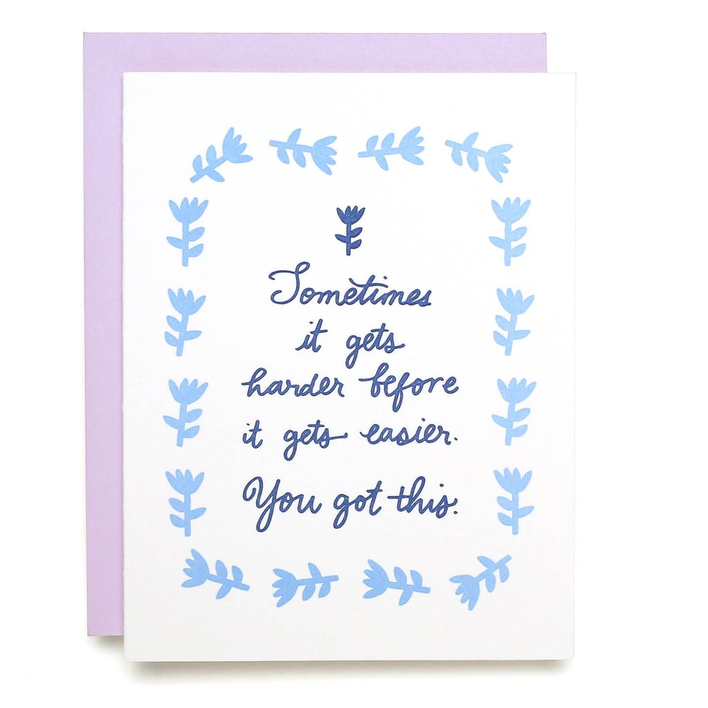 Greeting card with white background with a blue flower frame border and blue text says, "Sometimes it gets harder before it gets easier. You got this.". Lilac envelope included. 