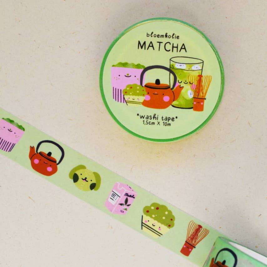 Image of roll of washi tape with light green background with images of a red tea pot, dog, box of matcha, whisk and cup of matcha. 