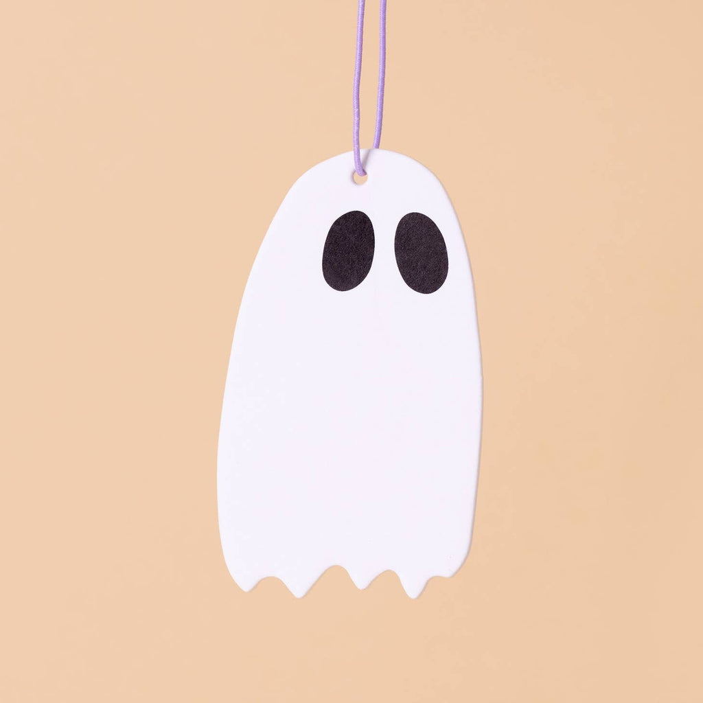 Image of white ghost with large black eyes hanging on a string. 