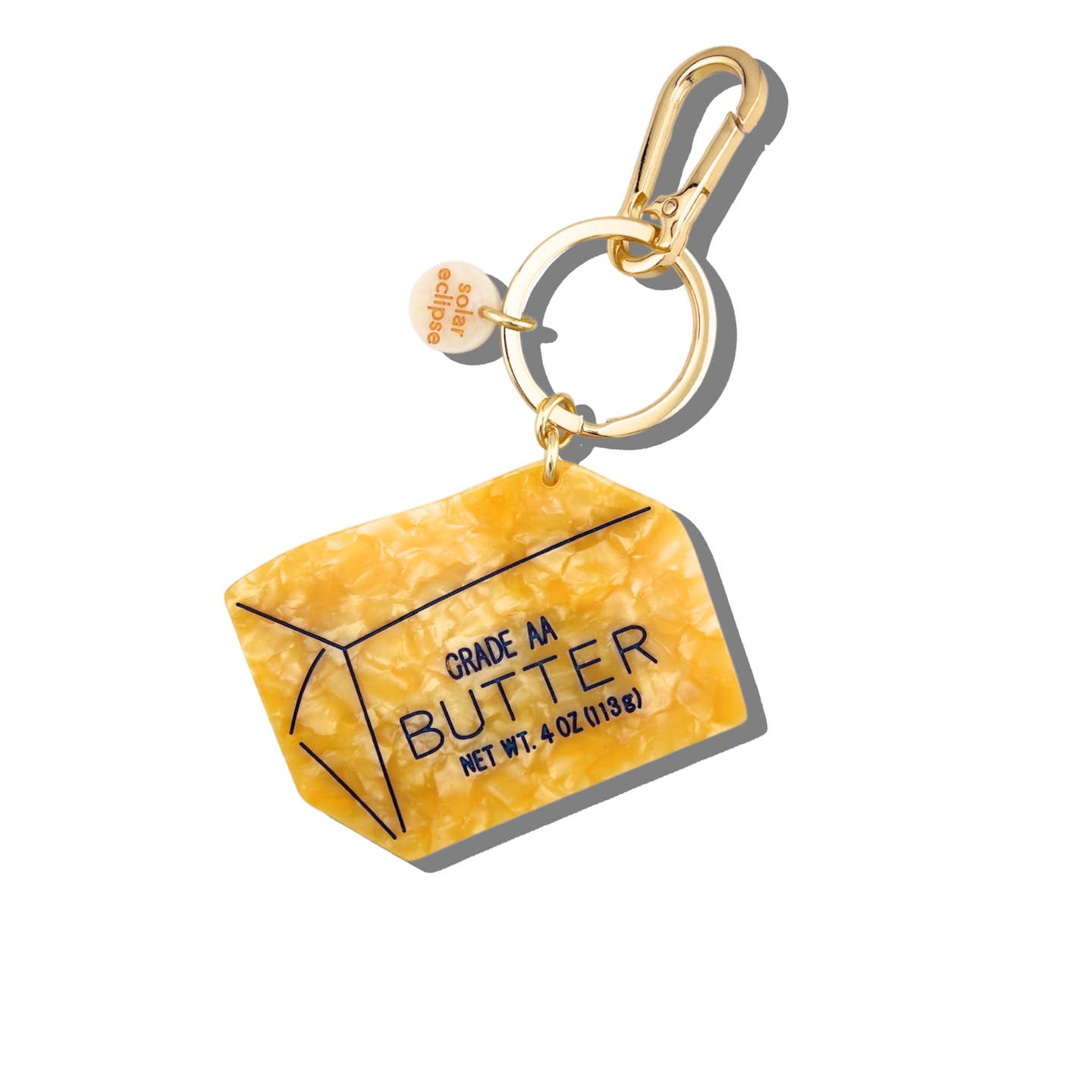 Image of a small stick of butter with blue text says, "Grade AA, Butter, Net Wt. 4 oz (113g)". Gold colored key ring and clip.