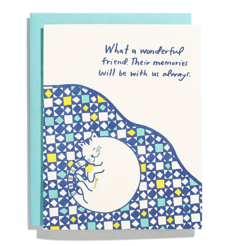 Greeting card with white background and image of a white cat curled up on a blue, yellow and aqua quilt. Blue text says, "What a wonderful friend. Their memories will be with us always.". Light blue envelope included. 