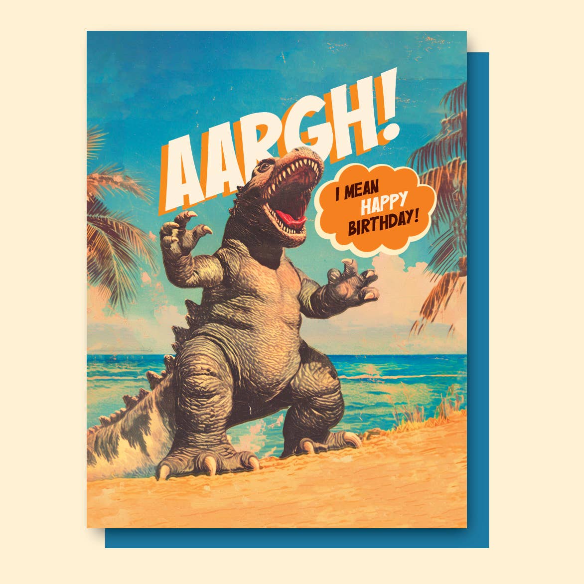 Greeting card with image of Godzilla  on the beach and white text says, "AARGH!" and black and white text says, "I mean happy birthday!" in an orange word bubble. Envelope included.