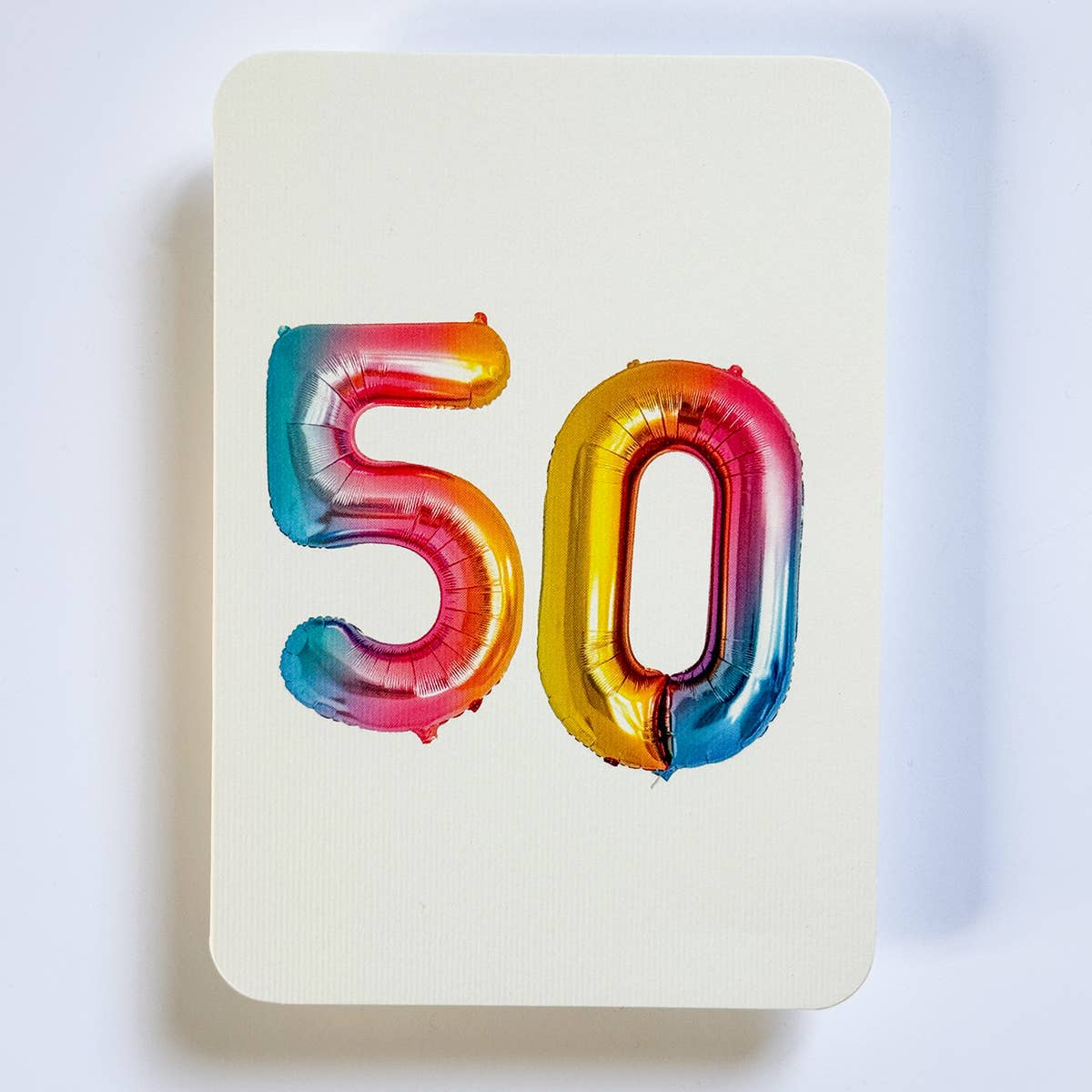 Greeting card with cream background and iridescent balloons "50". Envelope included. 