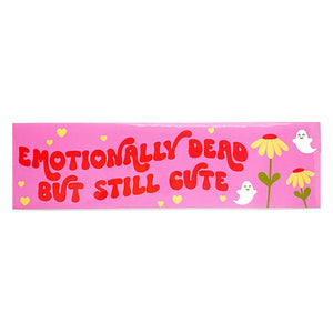 Decorative sticker with pink background and images of white ghosts and yellow flowers with red text says, "Emotionally dead but still cute". 