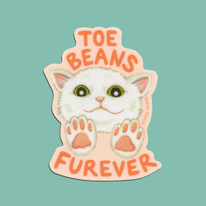 Decorative sticker with peach background and image of a white cat with pink toe beans and orange text says, "Toe beans furever". 