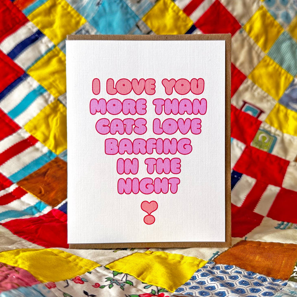 White background with bright pink puffy text says, "I love you more than cats love barfing in the night". Kraft envelope included. 