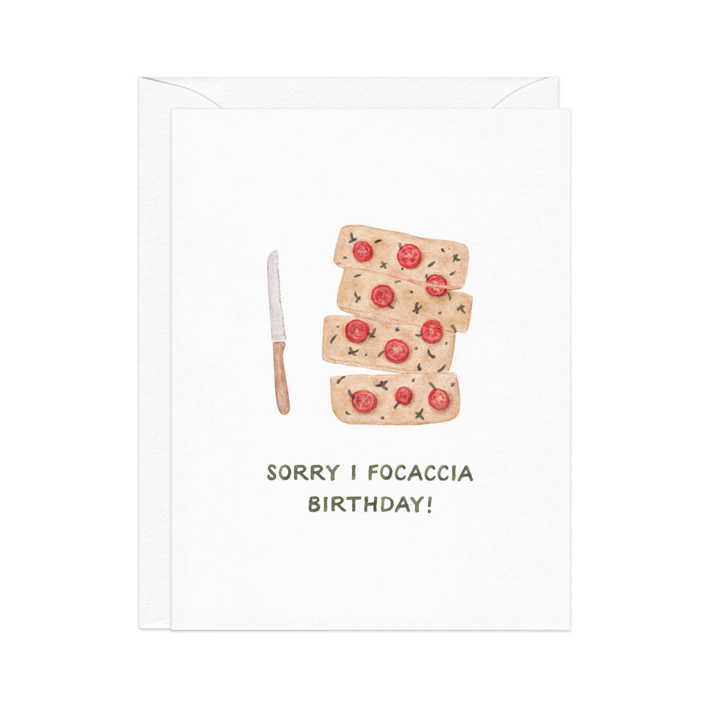 Greeting card with white background and image of focaccia bread with a knife and gray text says, "Sorry I focaccia birthay!". White envelope is included.