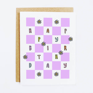 Lilac and white checkboard with images of daisies and multicolored text says, "Happy Birthday". Kraft envelope included. 