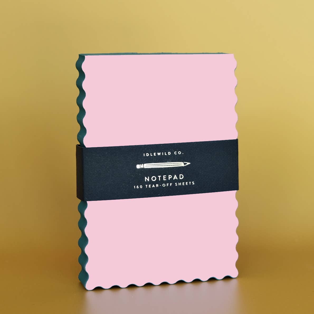 Notepad with pink background and green wavy edging.
