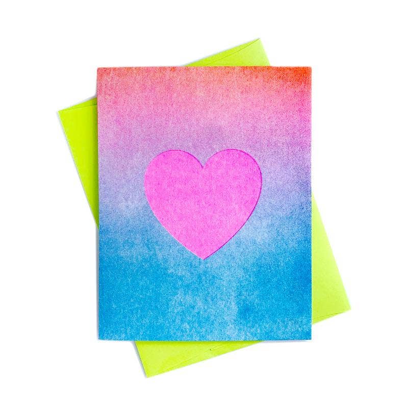 Greeting card with ombre of red, pink, purple and blue with bright pink heart in middle of card. Neon green envelope included. 