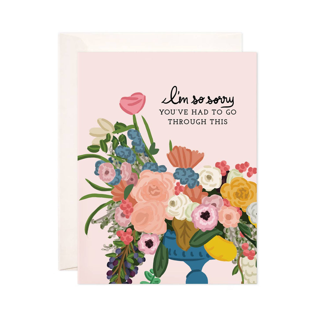 Pink background with image of blue vase of flowers in pink, peach, yellow, blue, and green with black text says, “I’m so sorry you’ve had to go through this”. White envelope included.      
