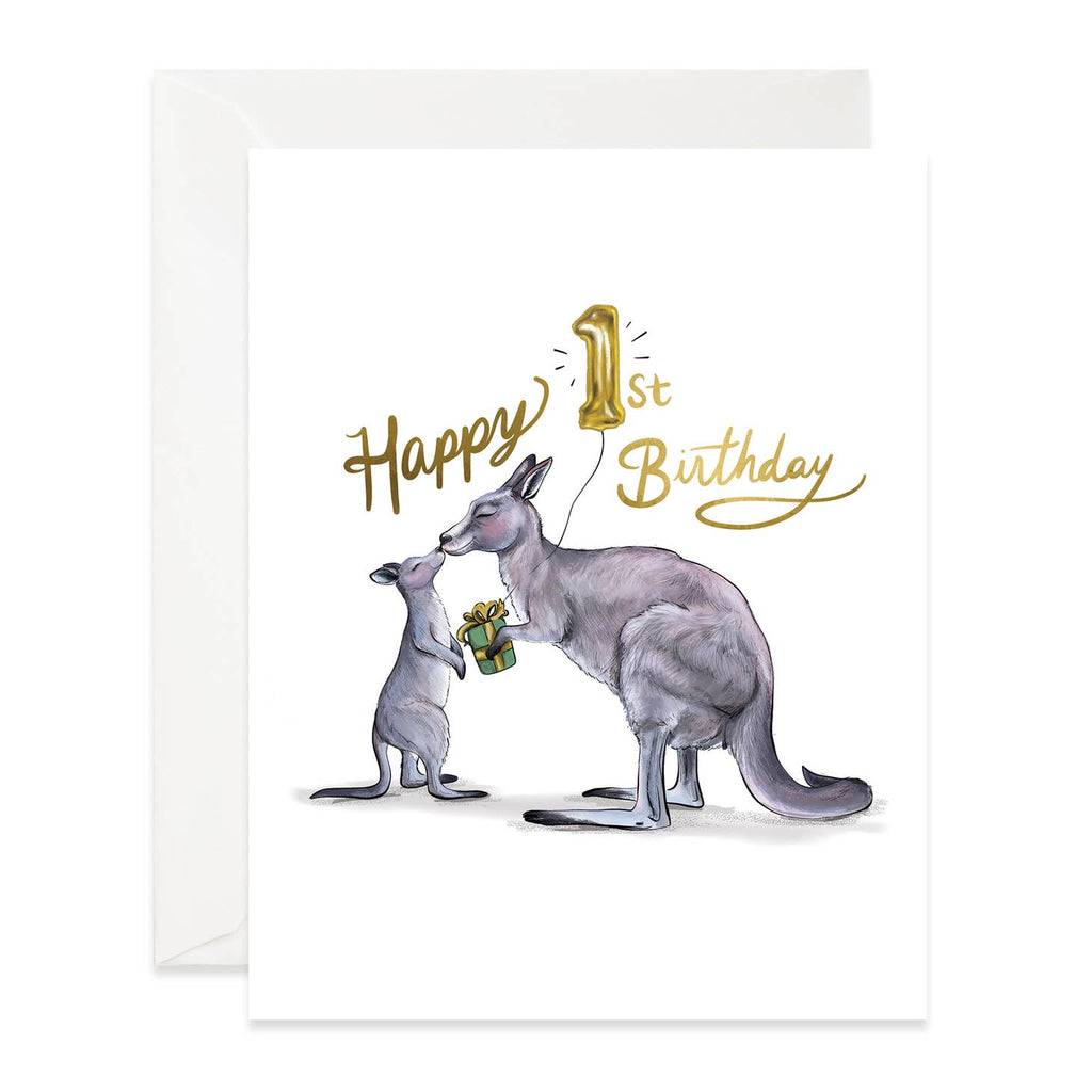 White background with image of an adult kangaroo kissing a baby kangaroo and giving a gift. Gold foil set says, "Happy 1st birthday". White envelope is included. 