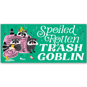 Bumper sticker with green background and image of three raccoons and a pink trash can. White text says, "Spoiled rotten trash goblin". 