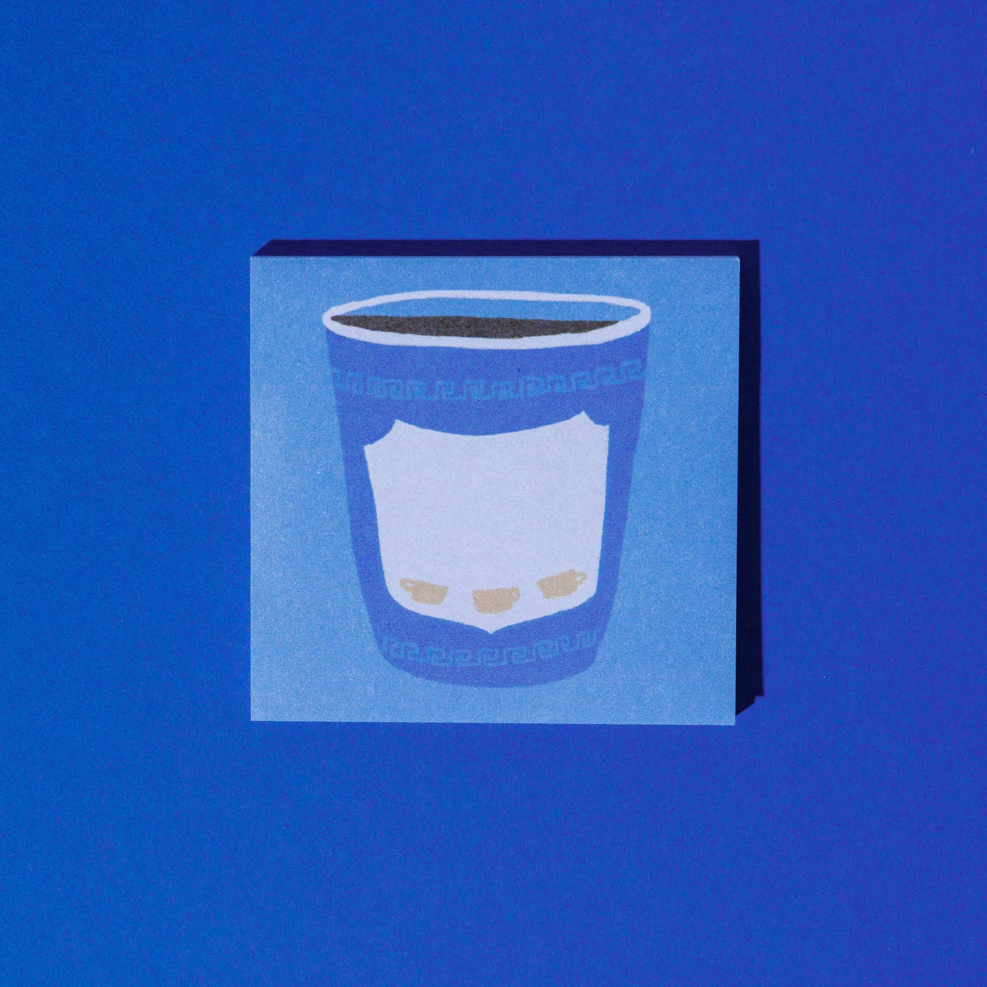 Sticky note pad with light blue background and image of a takeout coffee cup in blue with Grecian design.