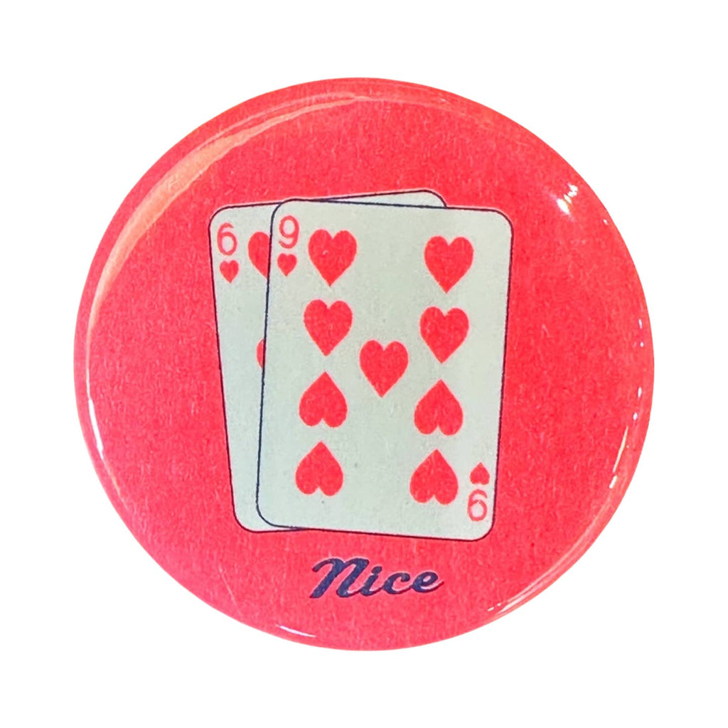 Image of metal button with orange/red background with image of two playing cards with red hearts and 6 and 9. Blue text says, "nice". 