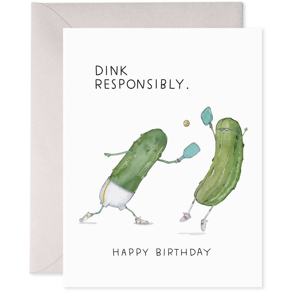 White background with image of two green pickles playing pickleball. Black text says, “Dink responsibly” and “Happy Birthday”. Grey envelope is included. 