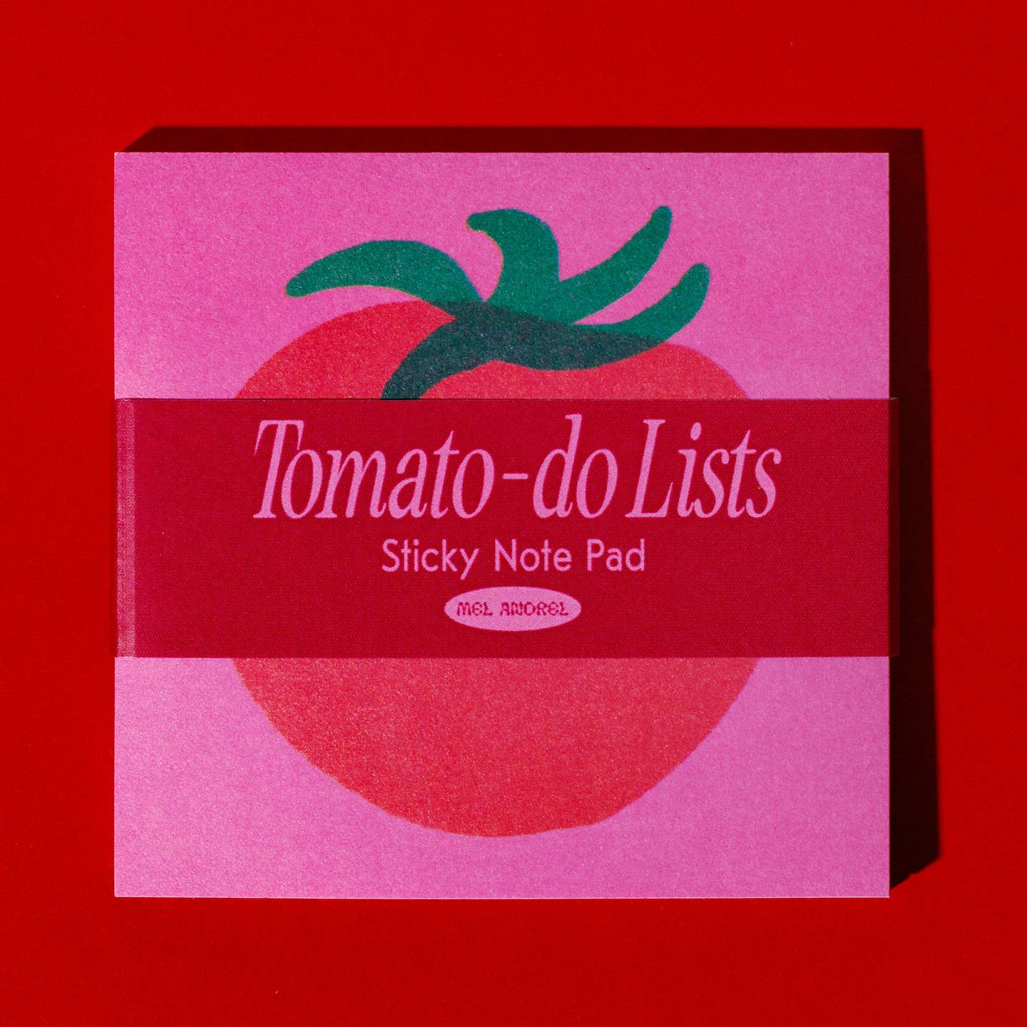 Sticky notepad with hot pink background and image of a red tomato with green stem in center.