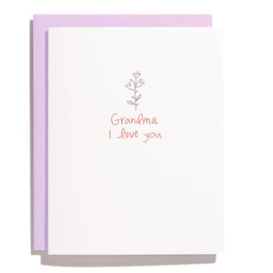 Greeting card with white background and lilac flower with pink text says, " Grandma I love you". Lilac envelope included. 