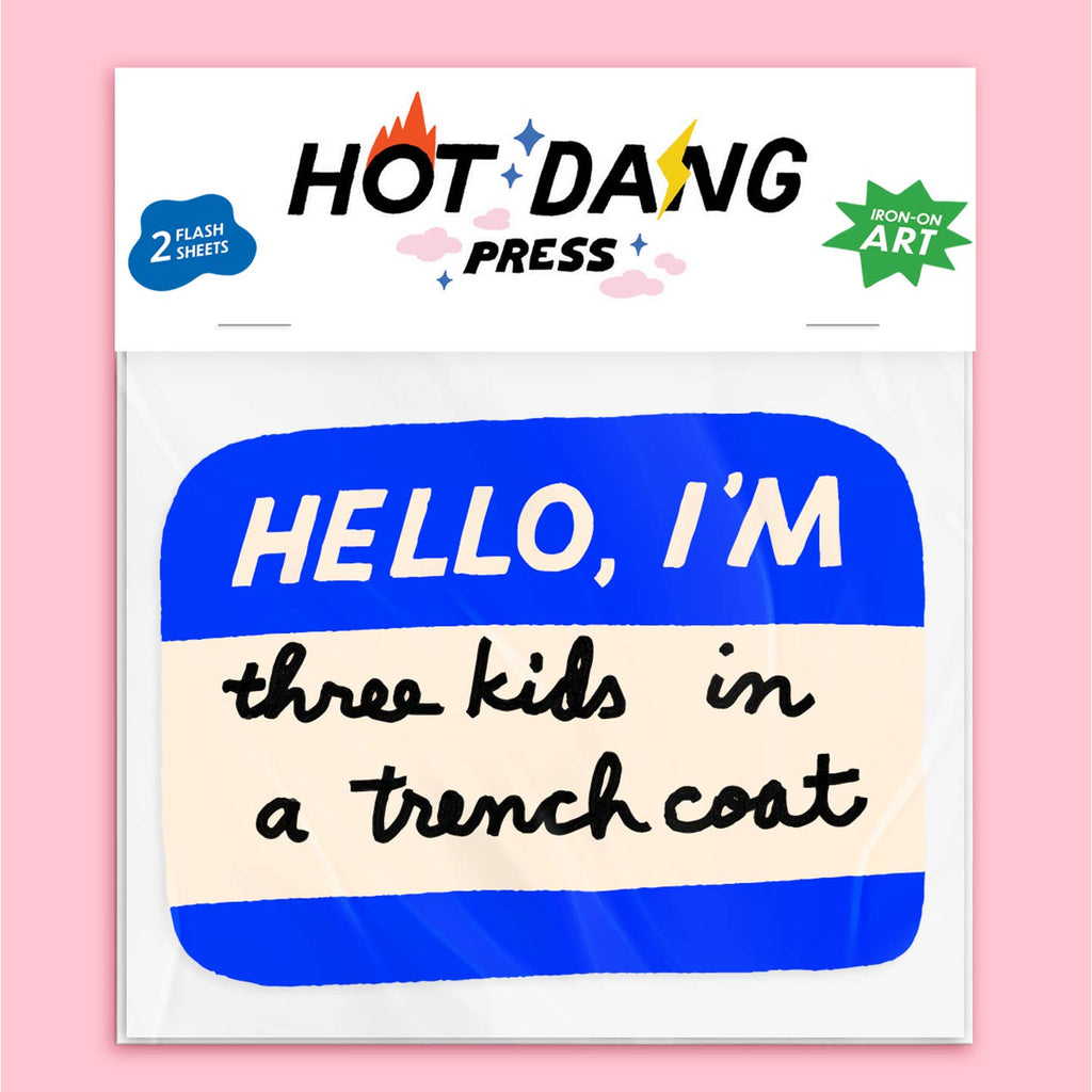 Image of iron on transfer in the shape of a blue and white Hello my name is sticker, Blue with white text says, "Hello I'm" and black text says, "three kids in a trench coat". 