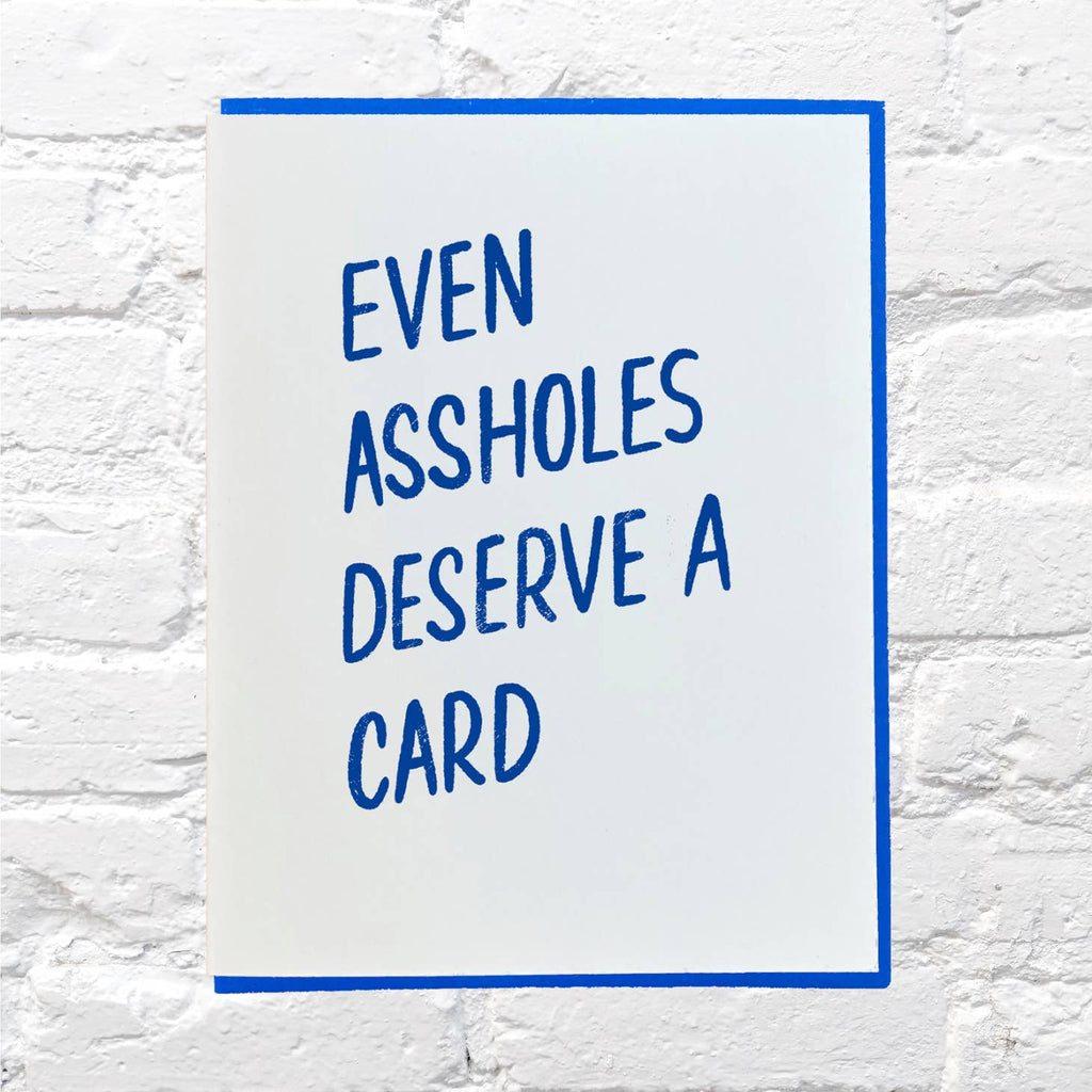 White background with blue text says, "Even assholes deserve a card". Blue envelope included.