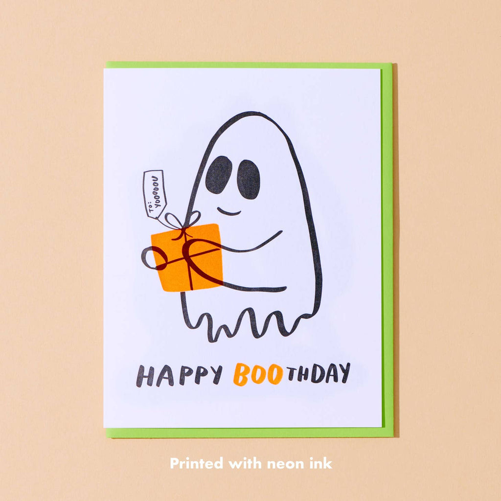 White background with black outlined ghost holding orange gift. Black and orange text says, “Happy Boothday”. Bright green envelope included. 