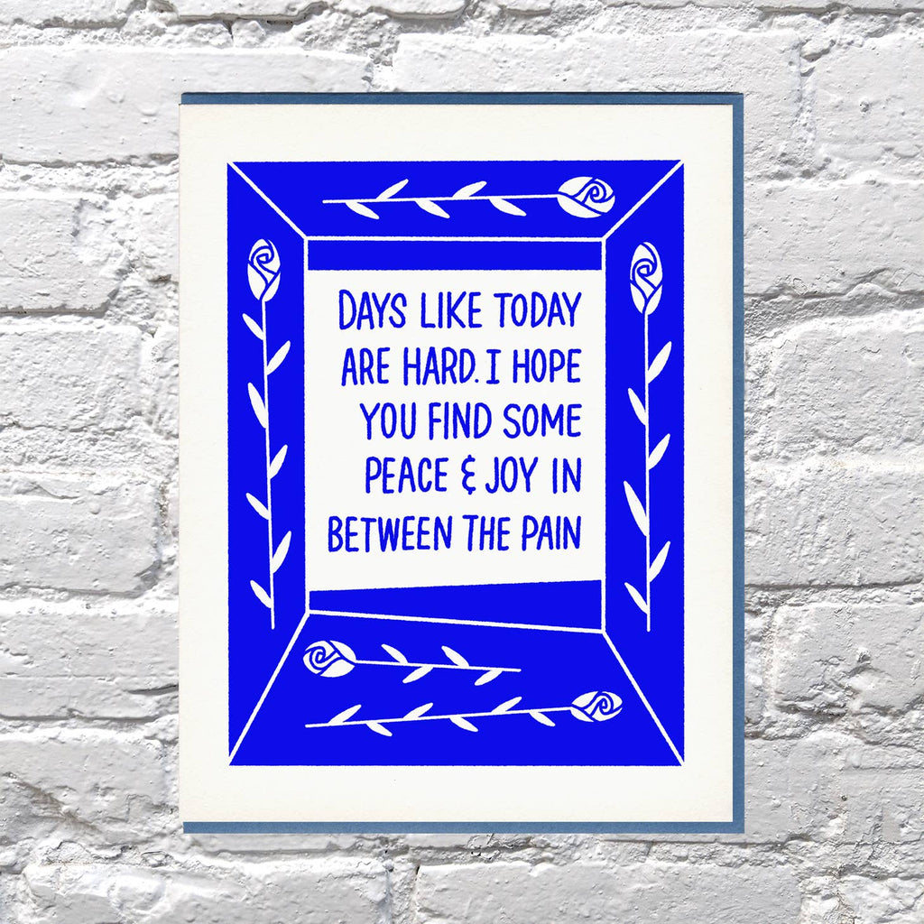Blue background with white border and white center with blue text says, "Days like today are hard. I hope you find some peace & joy in between the pain". Blue envelope is included. 