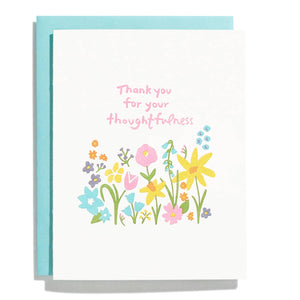 White background with flower garden in pink, aqua, orange, and yellow with pink text says, “Thank you for your thoughtfulness”. Aqua envelope is included. 