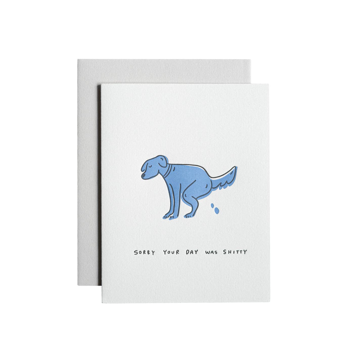 Greeting card with white background and image of a blue dog taking a shit. Black text says, "Sorry your day was shitty".  Grey envelope included.