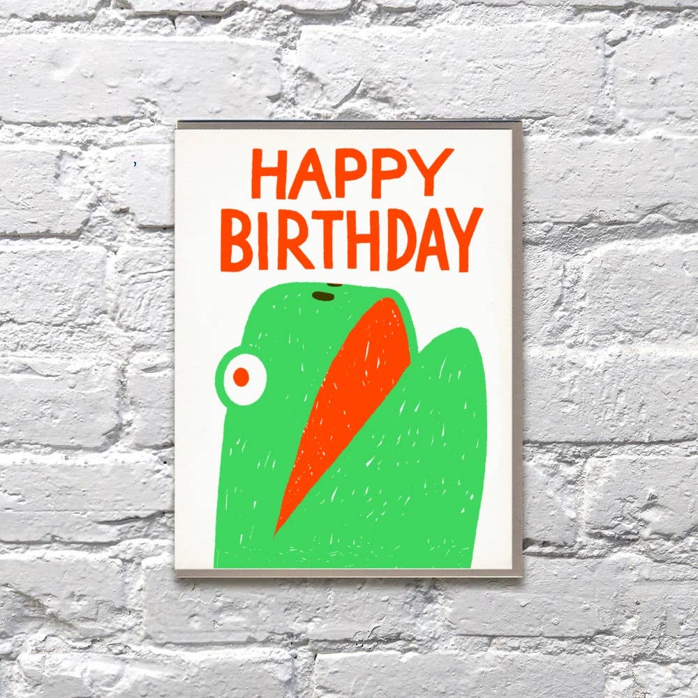 Greeting car with white background and head of a green turtle with red text says, "Happy Birthday". Envelope included. 