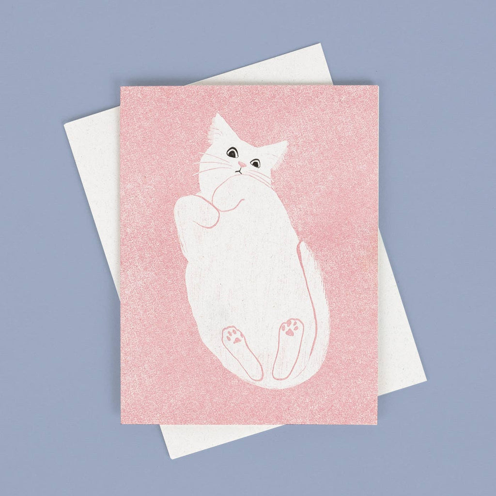 Pink background with image of white cat laying on its back. White envelope is included.