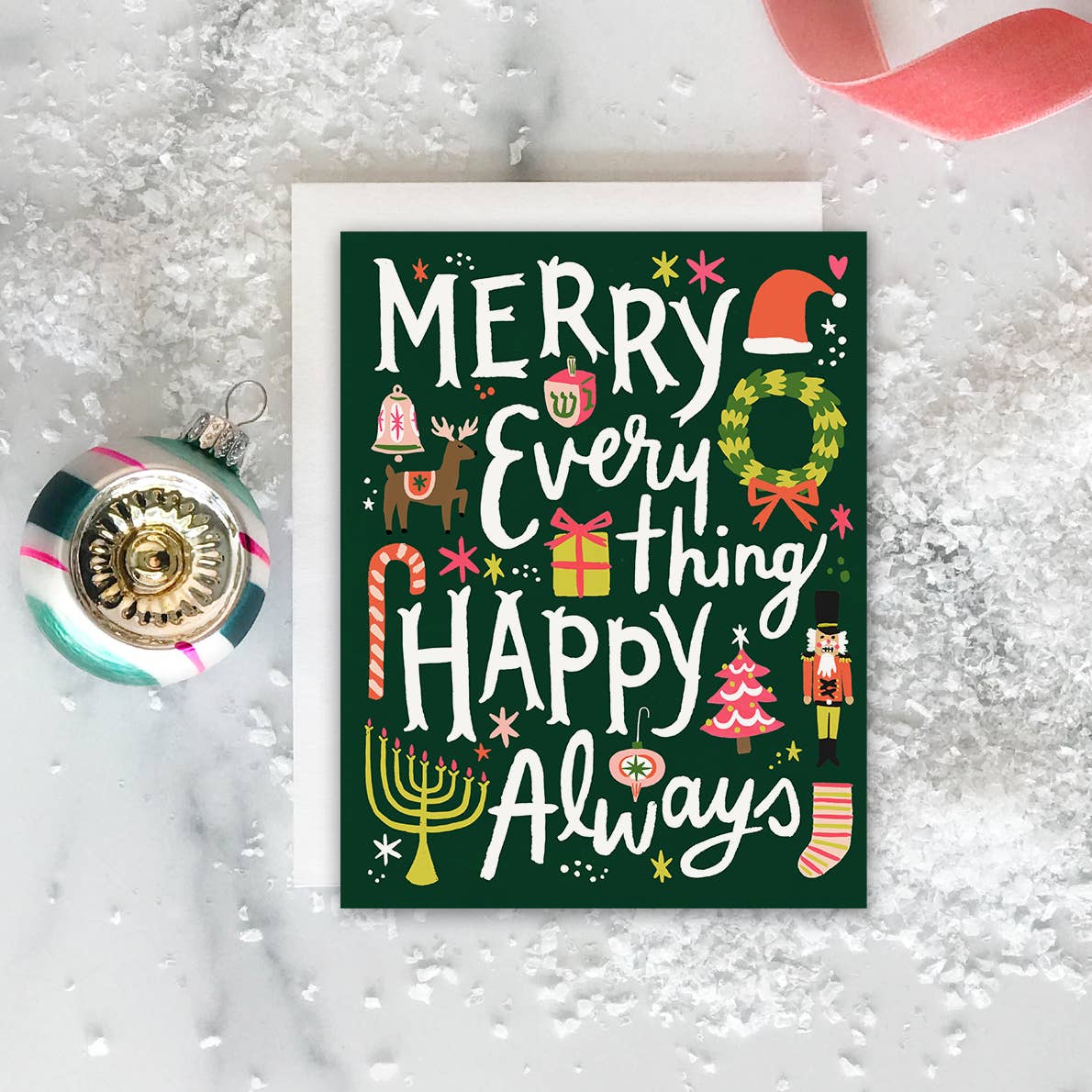 Greeting card with green background and white text says, "Merry every thing Happy Always" and images of Santa hat, wreath, menorah, tree, stocking and gifts. Envelope included. 