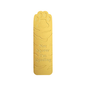 Image of brass cat leg and paw with engraved text says, “Not meow I’m reading”.        