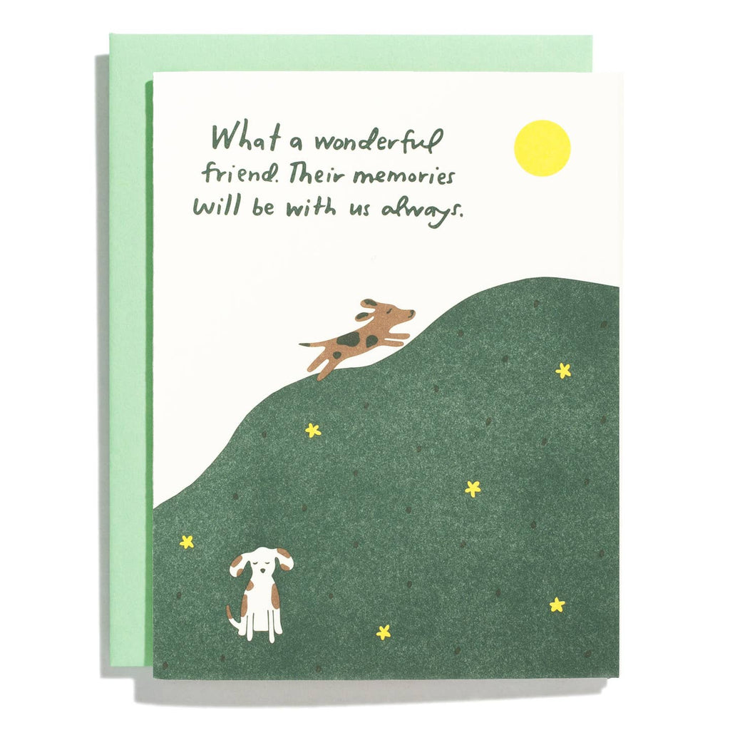 Greeting card with white background and image of a green hill with two dogs running and sitting on it. Green text says, "What a wonderful friend. Their memories will be with us always.". Light green envelope included. 