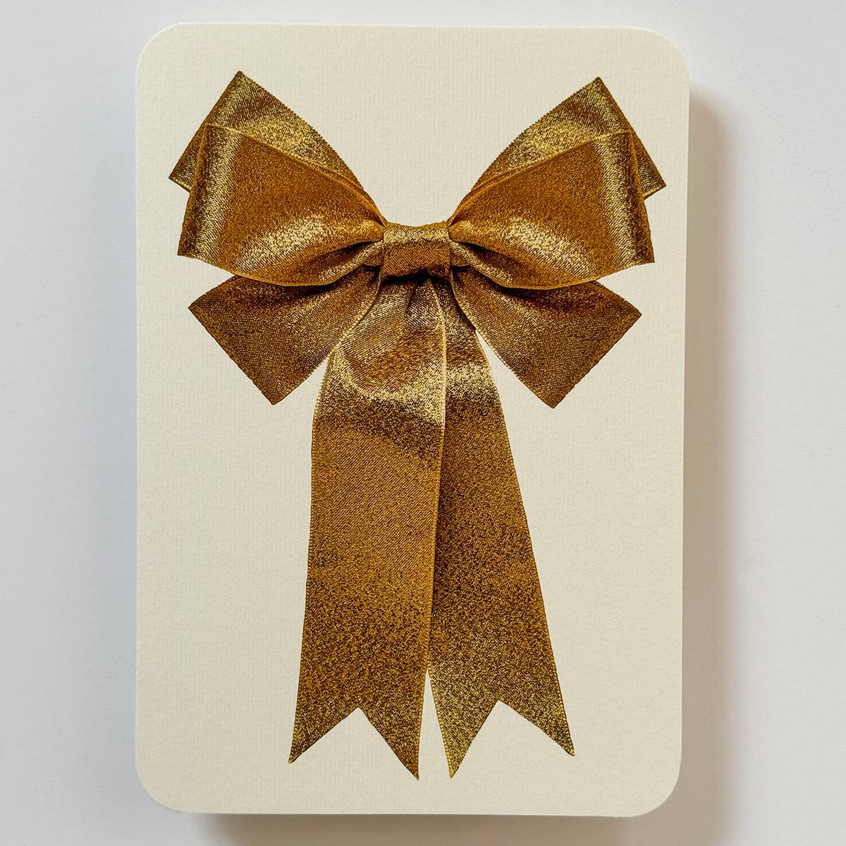 Greeting card with cream background with image of a gold bow. Envelope included.