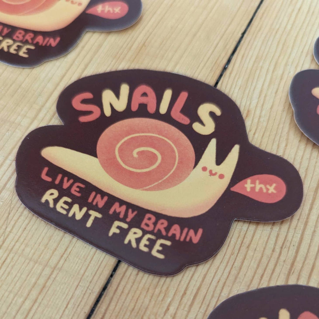 Image of pink and cream snail with a word bubble says, "Thx" and pink and cream text says, "Snails live in my brain rent free". 