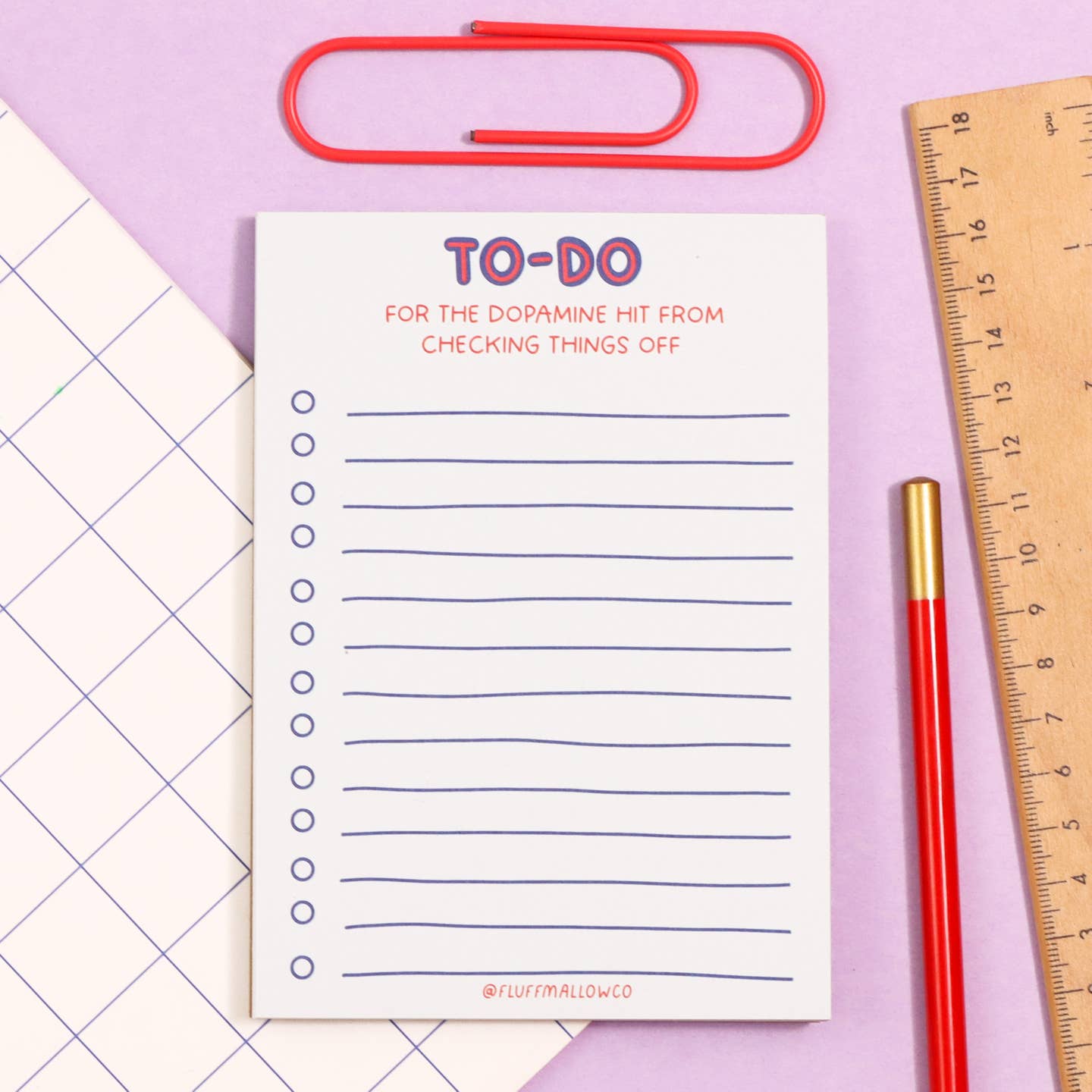 Notepad with white background and blue lines with blue circles for checkboxes. Orange text says, "To-Do", "For the dopamine hit from checking things off". 