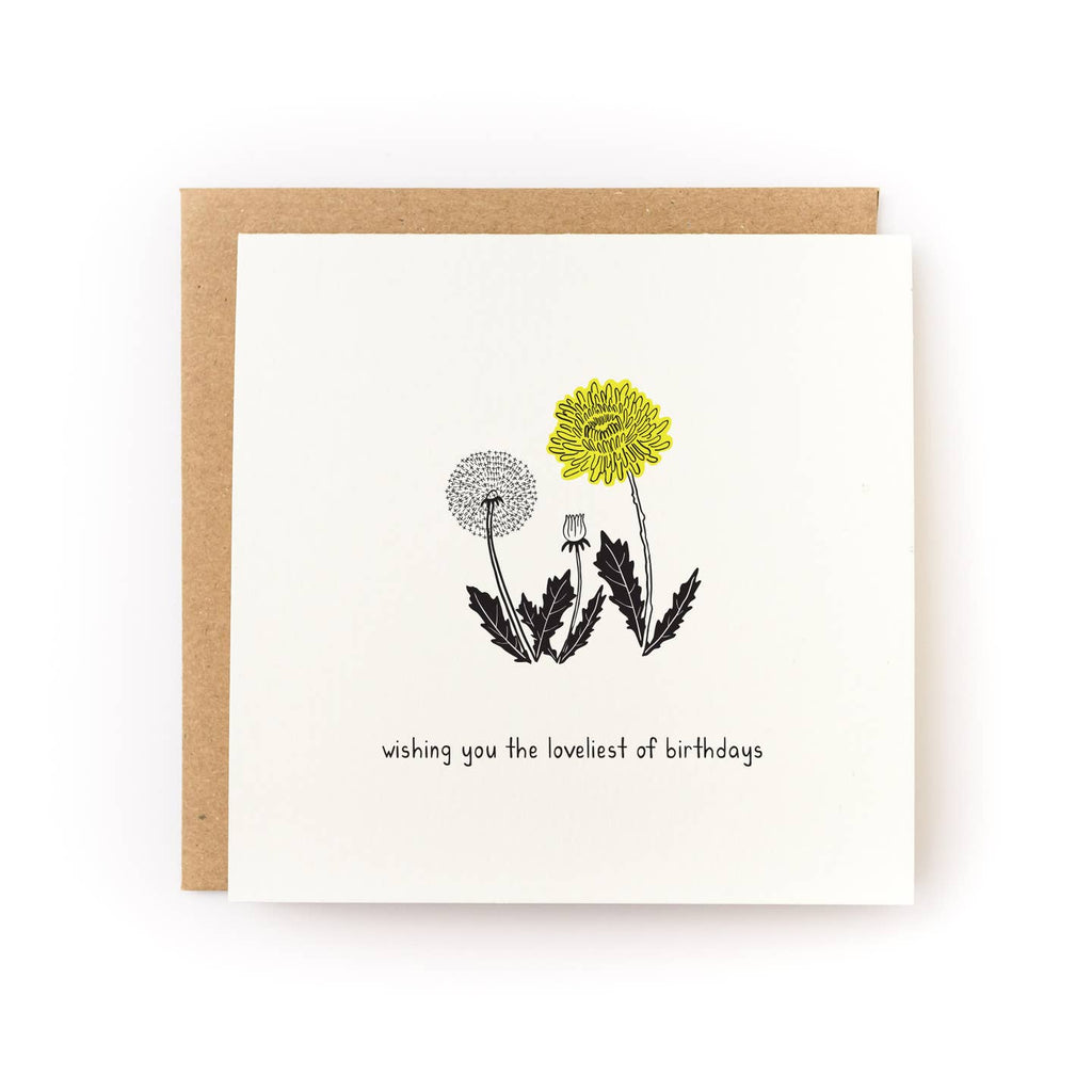 Greeting card with ivory background and image of a dandelion and black text says, "Wishing you the loveliest of birthdays". Kraft envelope included.