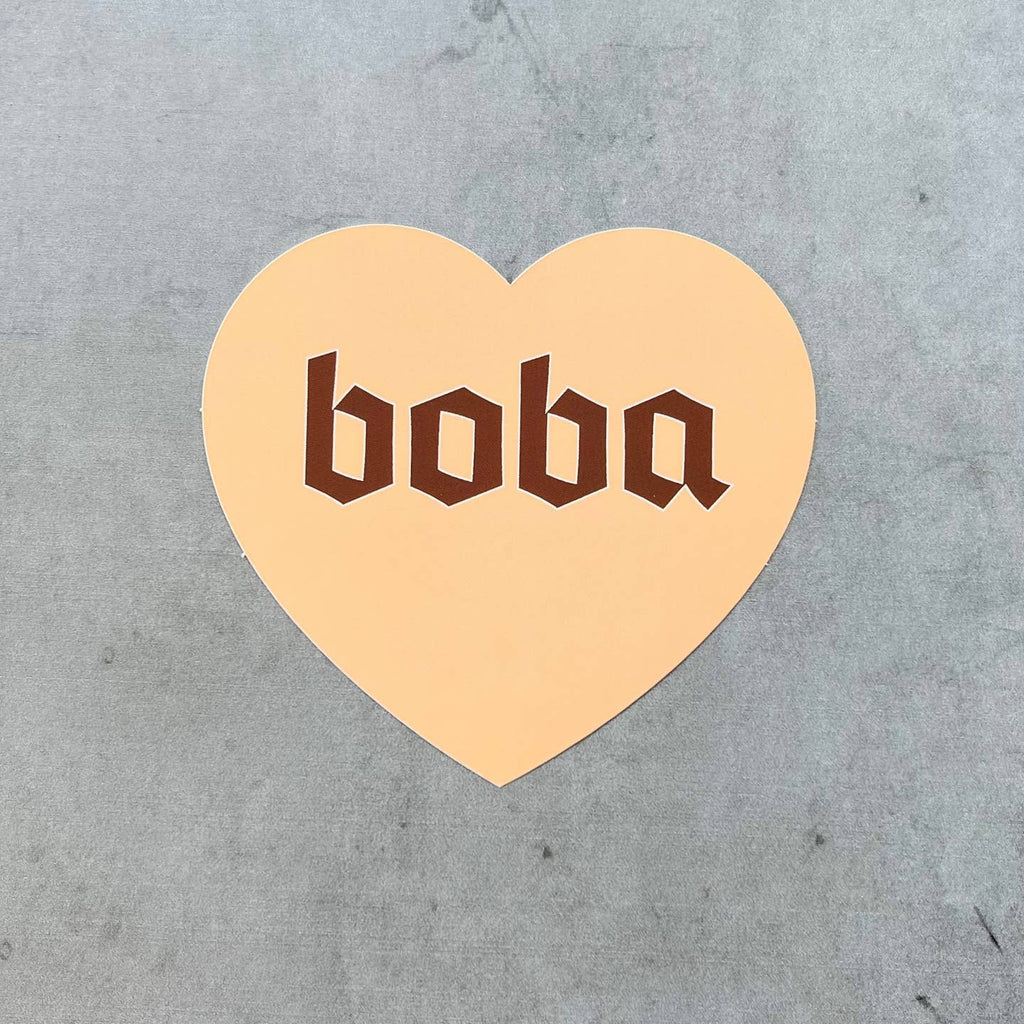 Heart shaped decorative sticker with peach background and brown text says, "Boba". 