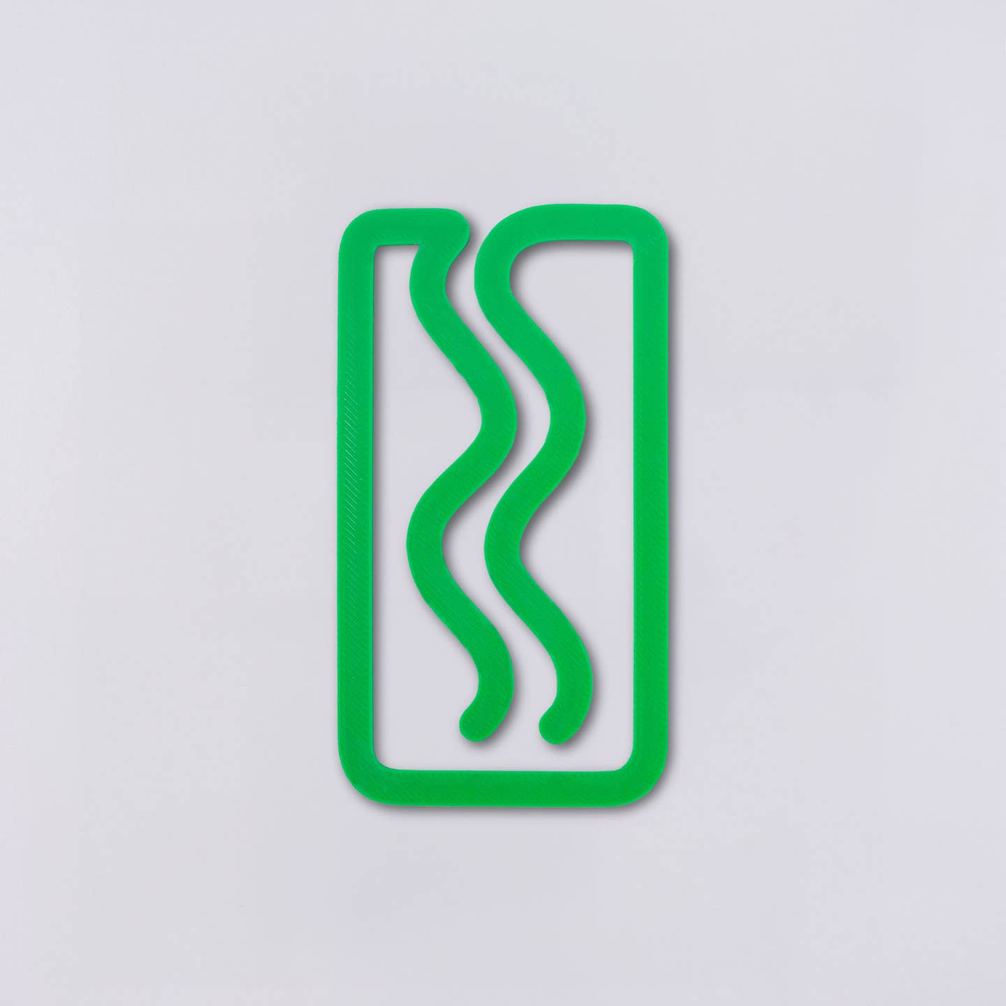 Plastic green bookmark in rectangle with squiggles.